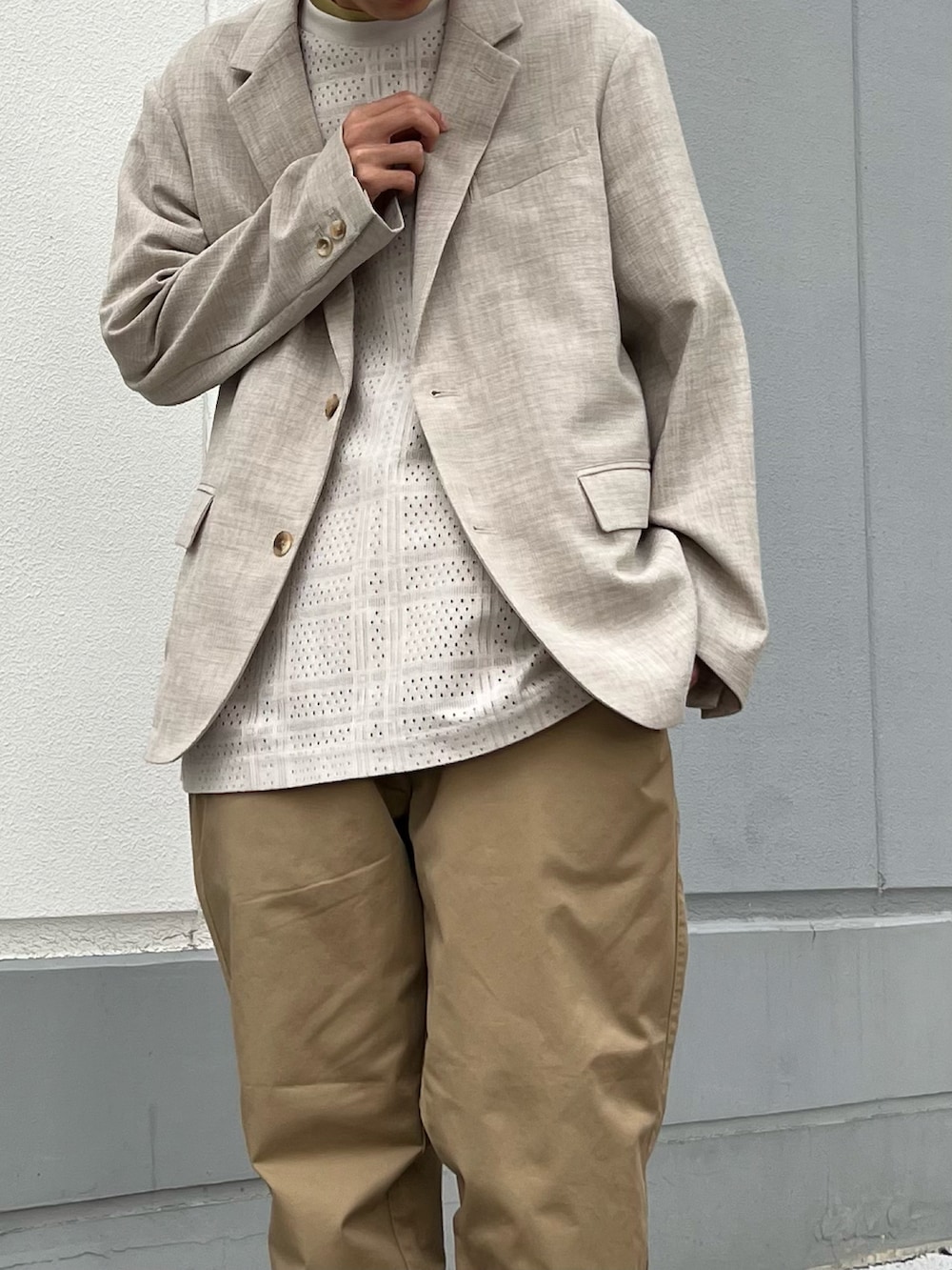 ホワイト系のテーラードジャケット、ブラック系のサンダル、ホワイト系のTシャツ/カットソーを着用したメンズの春コーディネートの2枚目の写真