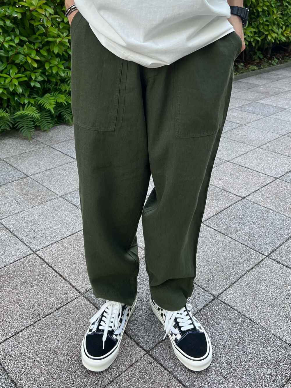 ホワイト系のTシャツ/カットソー、ブラック系のスニーカー、グリーン系のその他パンツを着用したメンズの夏コーディネートの4枚目の写真