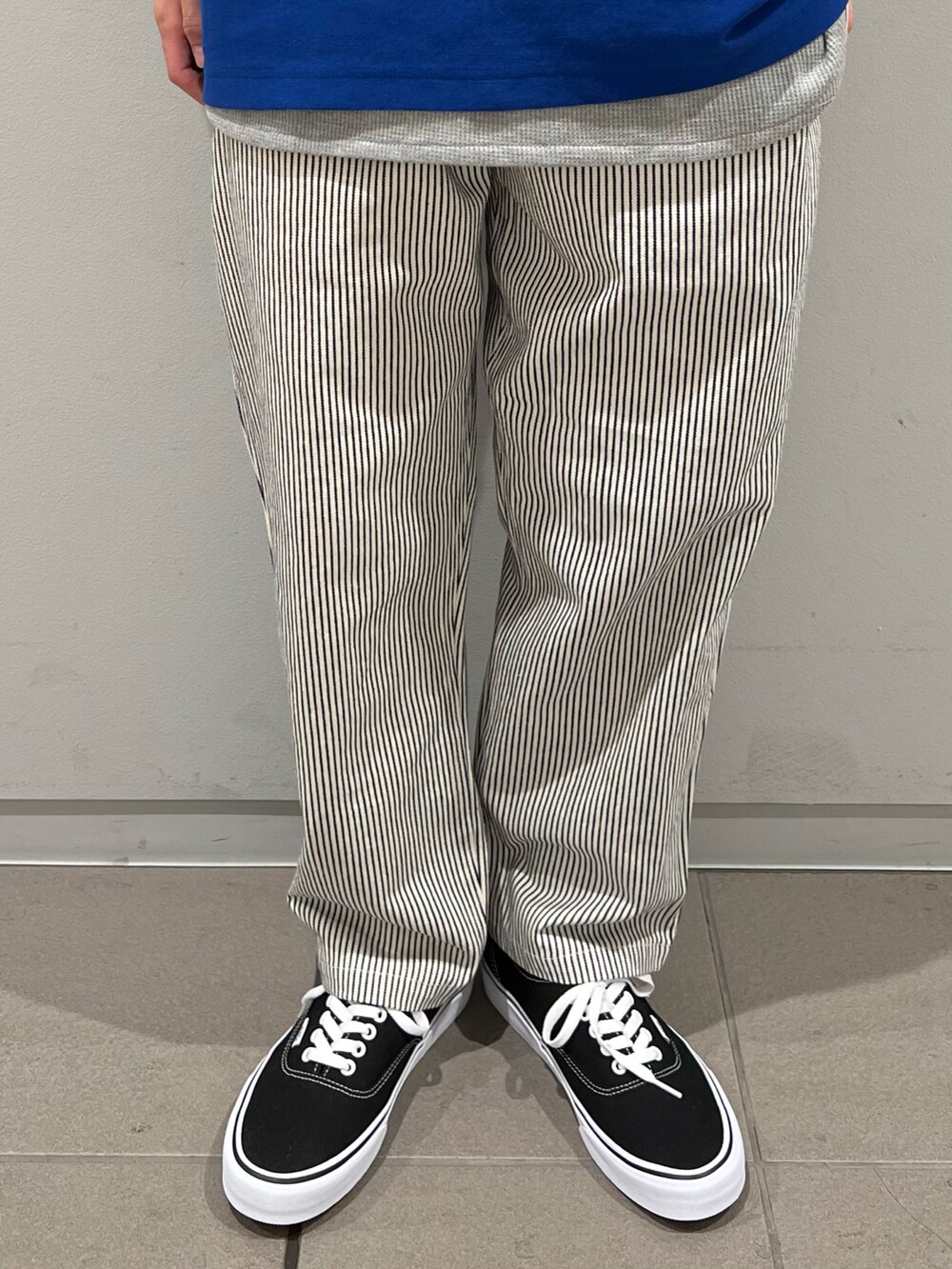ブルー系のTシャツ/カットソー、ホワイト系のデニムパンツ、ブラック系のスニーカーを着用したメンズの春コーディネートの3枚目の写真