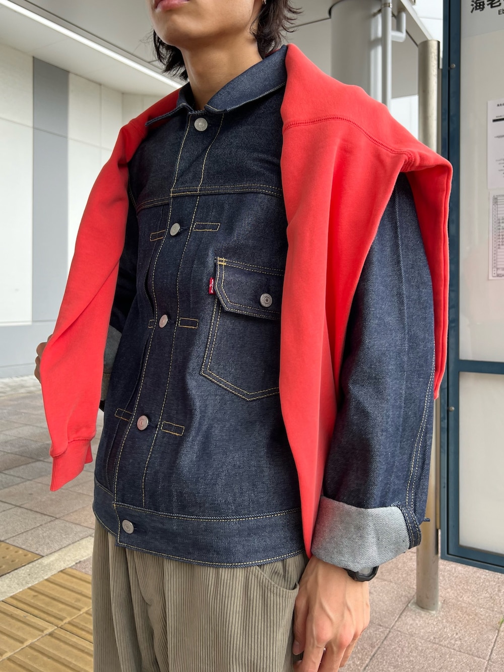 ピンク系のスウェット、ブルー系のデニムジャケット、ブラック系のサンダルを着用したメンズの秋コーディネートの4枚目の写真