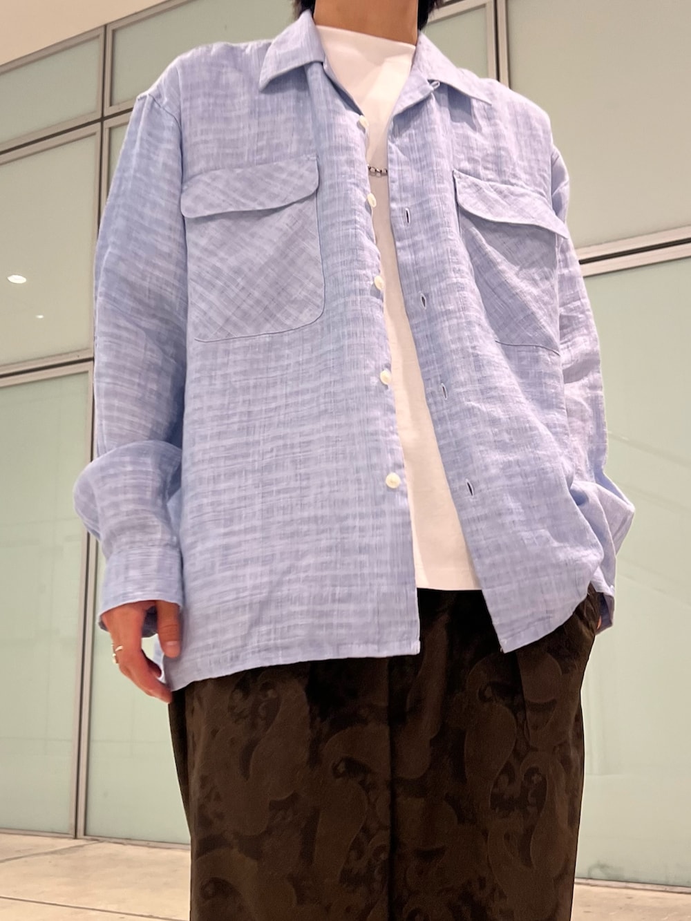 ホワイト系のTシャツ/カットソー、ブルー系のシャツ/ブラウス、ブラウン系のスラックスを着用したメンズの夏コーディネートの3枚目の写真