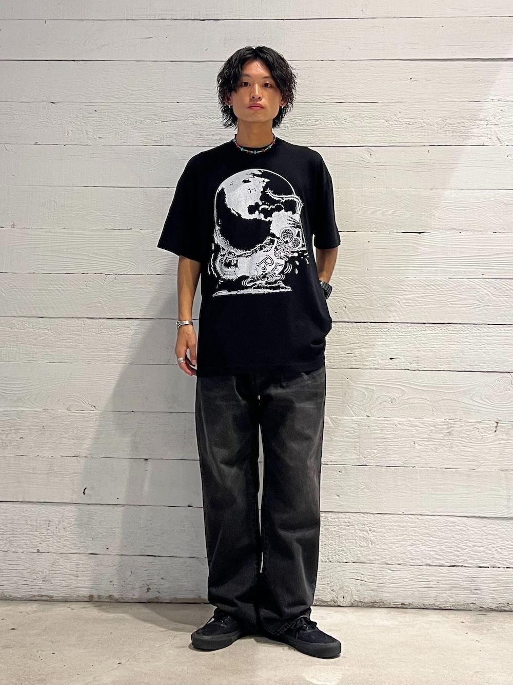 ベージュ系のミリタリージャケット、ブラック系のデニムパンツ、ブラック系のTシャツ/カットソーを着用したメンズの夏コーディネートの2枚目の写真