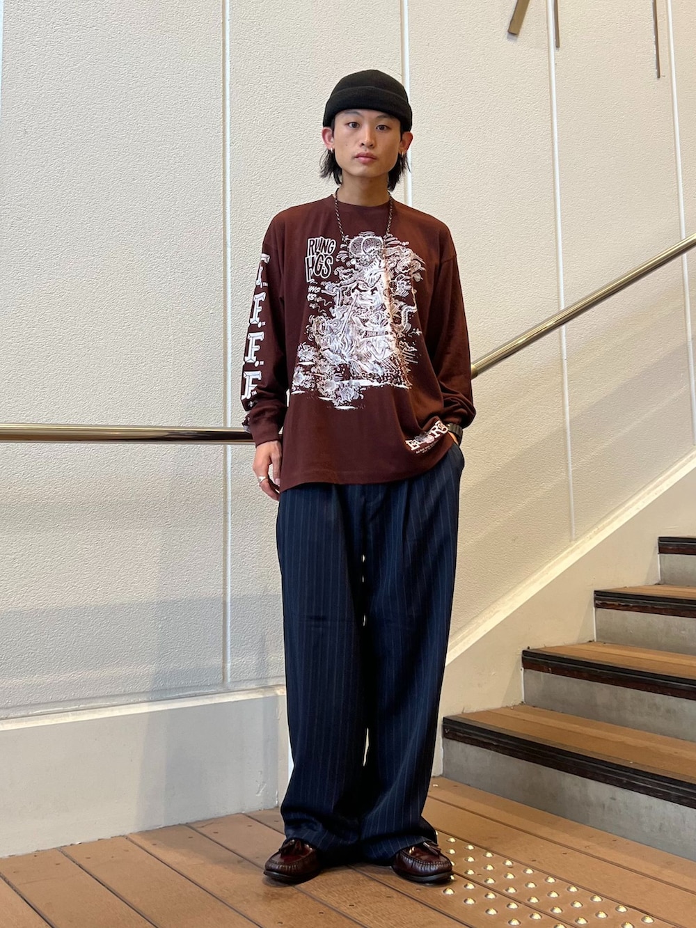 ブルー系のスラックス、ブラック系のシャツ/ブラウス、ブラウン系のTシャツ/カットソーを着用したメンズの秋コーディネートの2枚目の写真