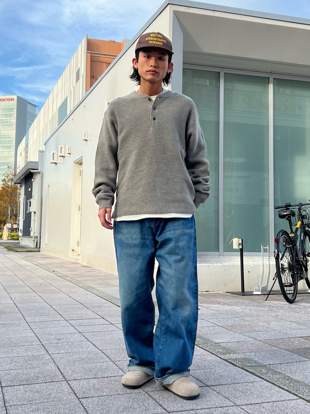 グレー系のニット/セーター、ホワイト系のTシャツ/カットソー、ブラック系のテーラードジャケットを着用したメンズの秋コーディネートの2枚目の写真