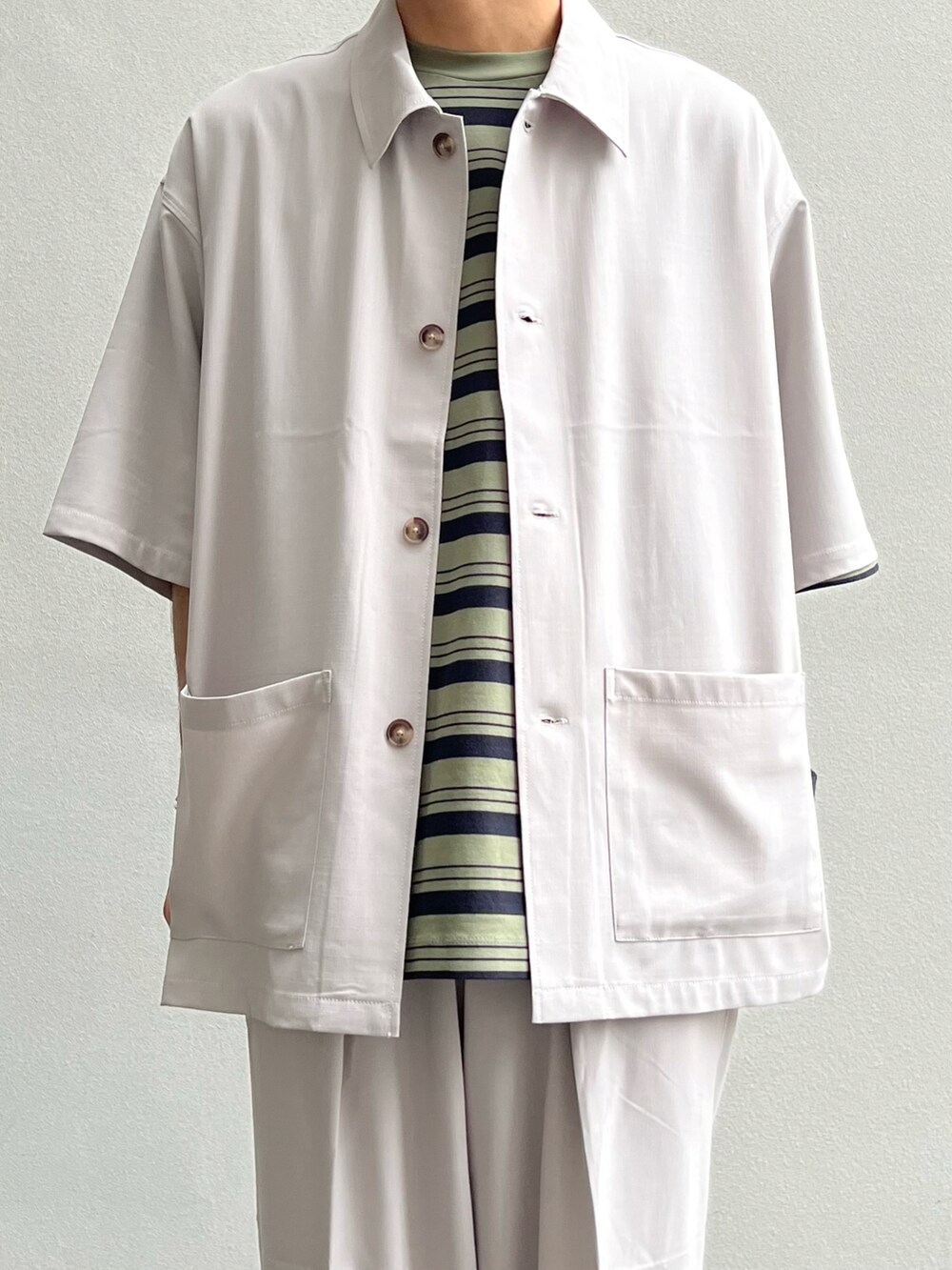 ホワイト系のシャツ/ブラウス、グリーン系のTシャツ/カットソー、ホワイト系のスラックスを着用したメンズの夏コーディネートの2枚目の写真