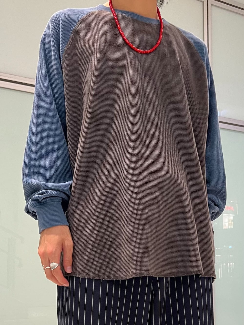ブラック系のスラックス、ブルー系のTシャツ/カットソー、ブラック系のショルダーバッグを着用したメンズの夏コーディネートの2枚目の写真