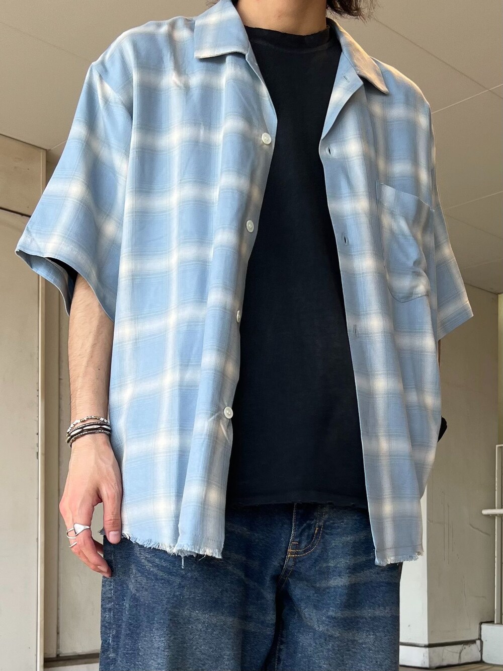 ブルー系のデニムパンツ、ブルー系のシャツ/ブラウス、ブラック系のTシャツ/カットソーを着用したメンズの春コーディネートの3枚目の写真