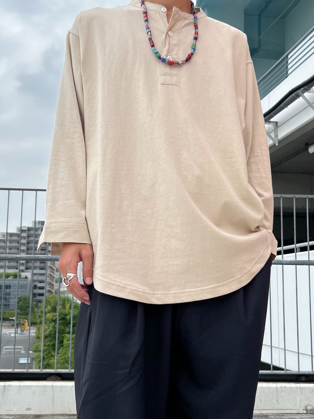 ブラック系のスラックス、ブルー系のカーディガン/ボレロ、ベージュ系のTシャツ/カットソーを着用したメンズの夏コーディネートの5枚目の写真