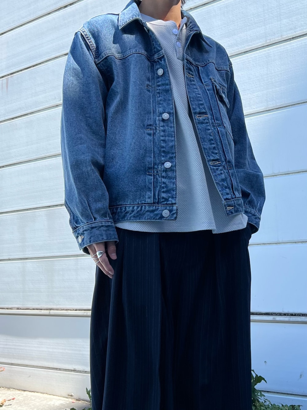 ブルー系のデニムジャケット、ベージュ系のTシャツ/カットソー、ブルー系のスラックスを着用したメンズの春コーディネートの2枚目の写真