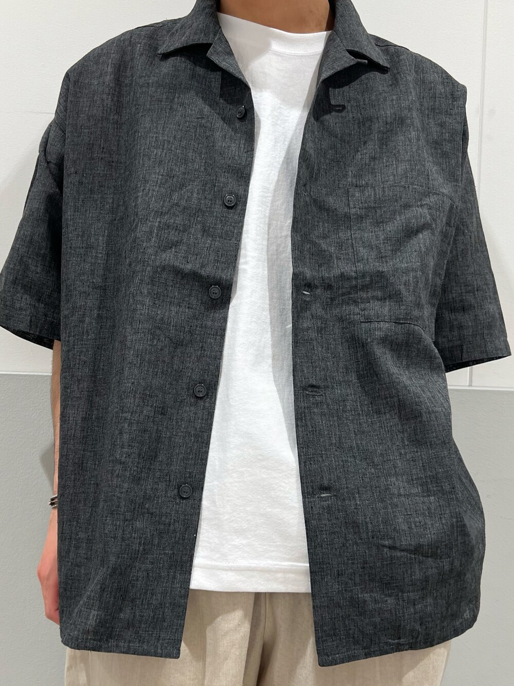 ブラック系のシャツ/ブラウス、ホワイト系のTシャツ/カットソー、ベージュ系のその他パンツを着用したメンズの春コーディネートの2枚目の写真