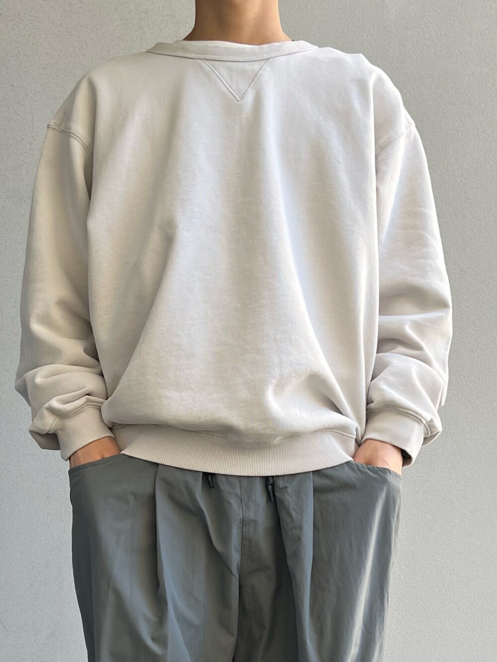 グレー系のカーゴパンツ、ブラック系のその他シューズ、ベージュ系のスウェットを着用したメンズの春コーディネートの2枚目の写真