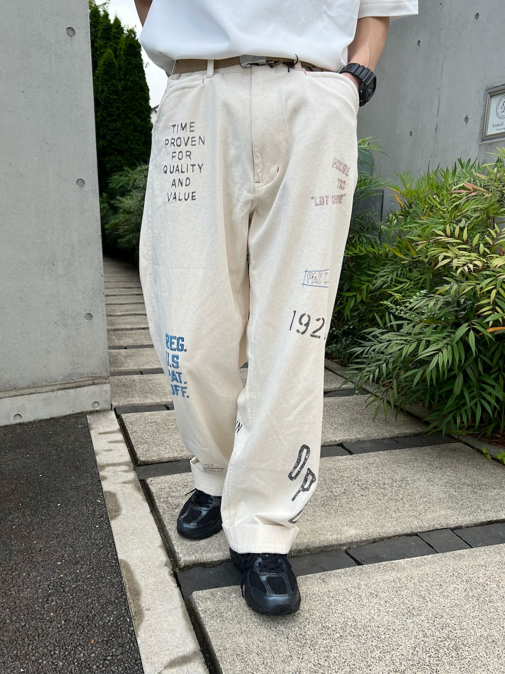 ホワイト系のTシャツ/カットソー、ホワイト系のその他パンツ、ブラック系のスニーカーを着用したメンズの夏コーディネートの2枚目の写真