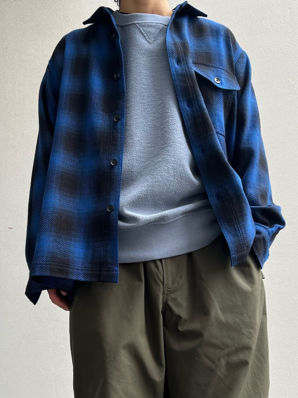 ブルー系のスウェット、ブルー系のシャツ/ブラウス、グレー系のスニーカーを着用したメンズの冬コーディネートの4枚目の写真