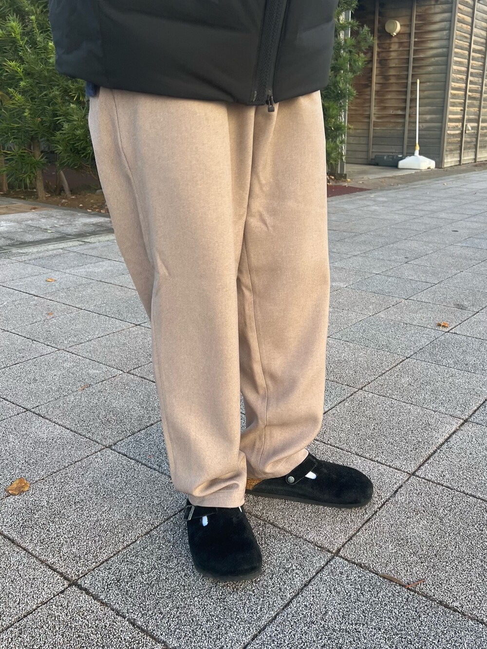 ブラック系のダウンジャケット/コート、ブルー系のニット/セーター、ブラック系のサンダルを着用したメンズの冬コーディネートの6枚目の写真