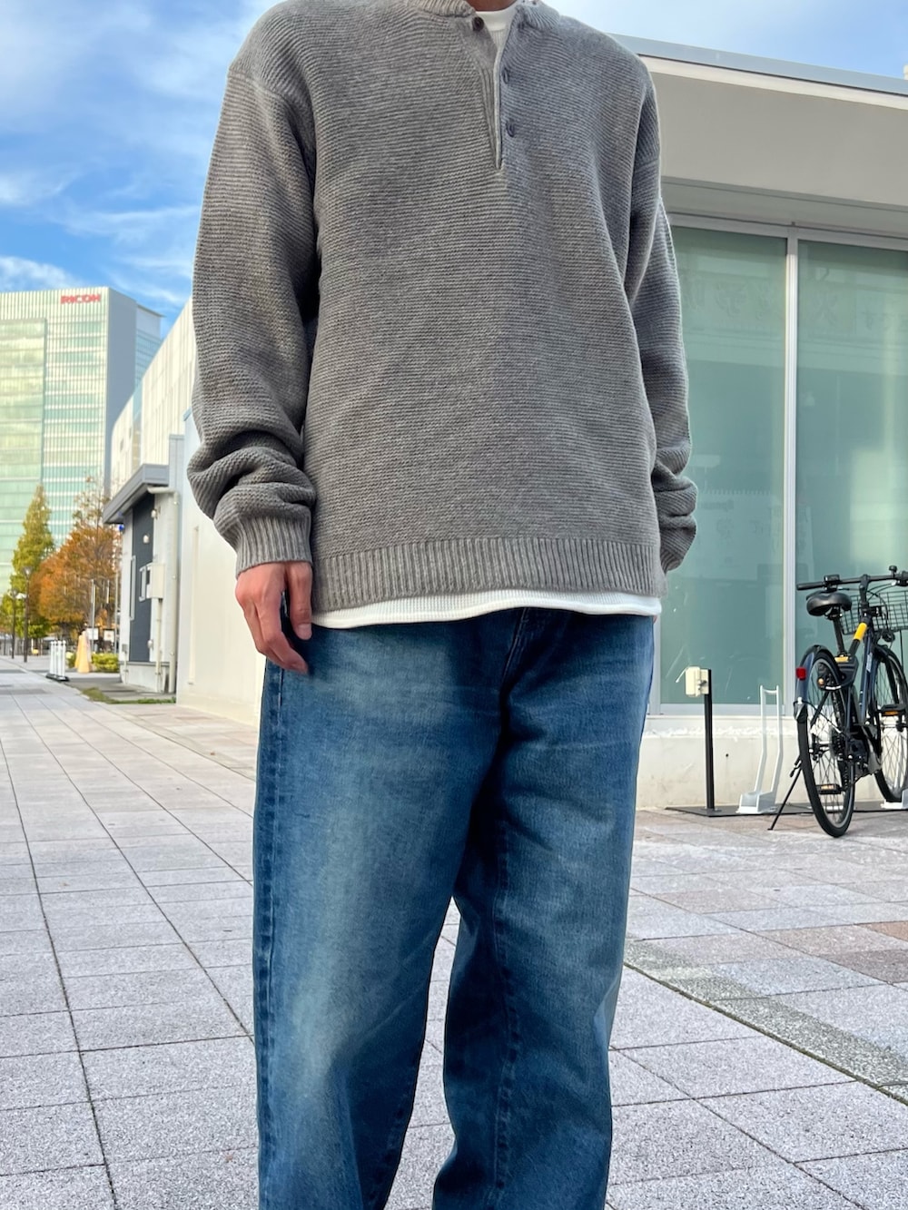 グレー系のニット/セーター、ホワイト系のTシャツ/カットソー、ブラック系のテーラードジャケットを着用したメンズの秋コーディネートの4枚目の写真