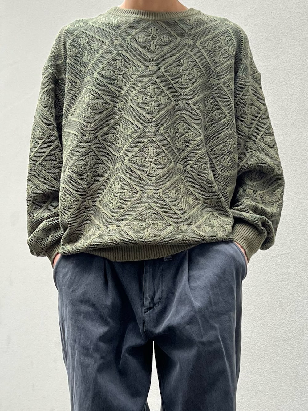 グリーン系のニット/セーター、ブラック系のデニムパンツ、ブラウン系のブーツを着用したメンズの冬コーディネートの2枚目の写真