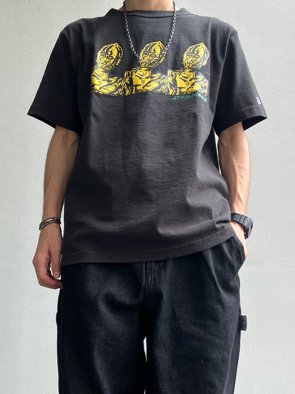 ブラック系のTシャツ/カットソー、ブラック系のサンダル、ブラック系のデニムパンツを着用したメンズの夏コーディネートの2枚目の写真