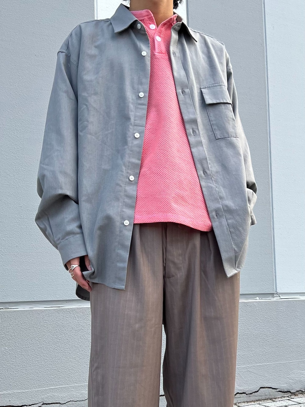 ブラウン系のスラックス、グレー系のシャツ/ブラウス、ピンク系のTシャツ/カットソーを着用したメンズの冬コーディネートの3枚目の写真