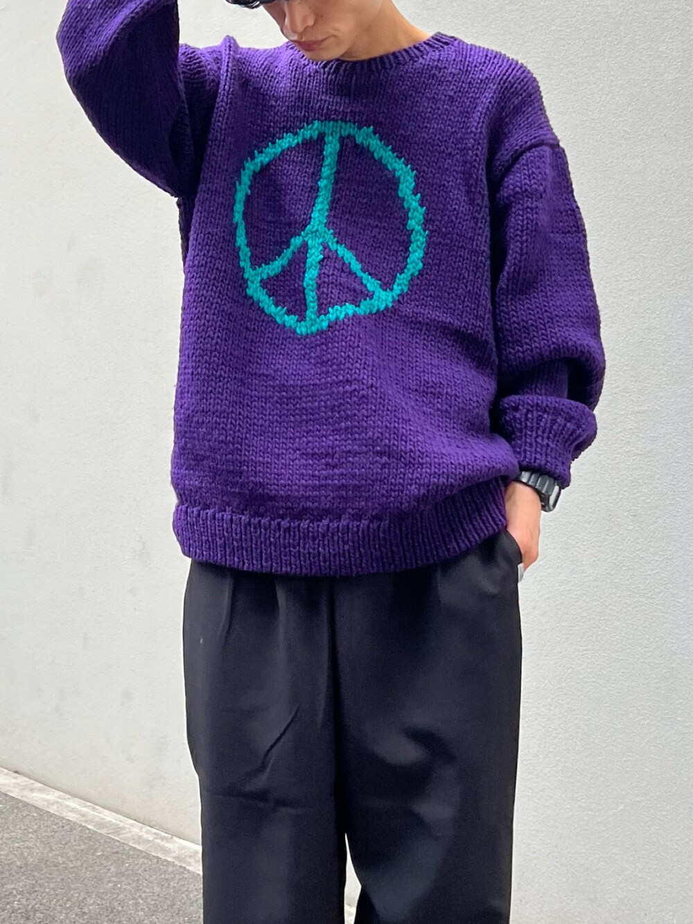 ブラック系のスラックス、パープル系のニット/セーター、ブラウン系のブーツを着用したメンズの冬コーディネートの2枚目の写真