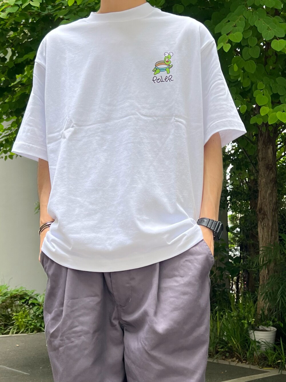 ホワイト系のTシャツ/カットソー、グレー系のスラックス、ブラック系のその他シューズを着用したメンズの夏コーディネートの2枚目の写真