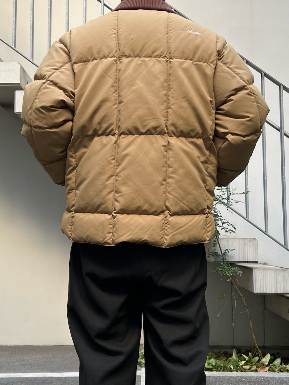 ベージュ系のダウンジャケット/コート、グレー系のスウェット、ブラック系のスラックスを着用したメンズの秋コーディネートの5枚目の写真