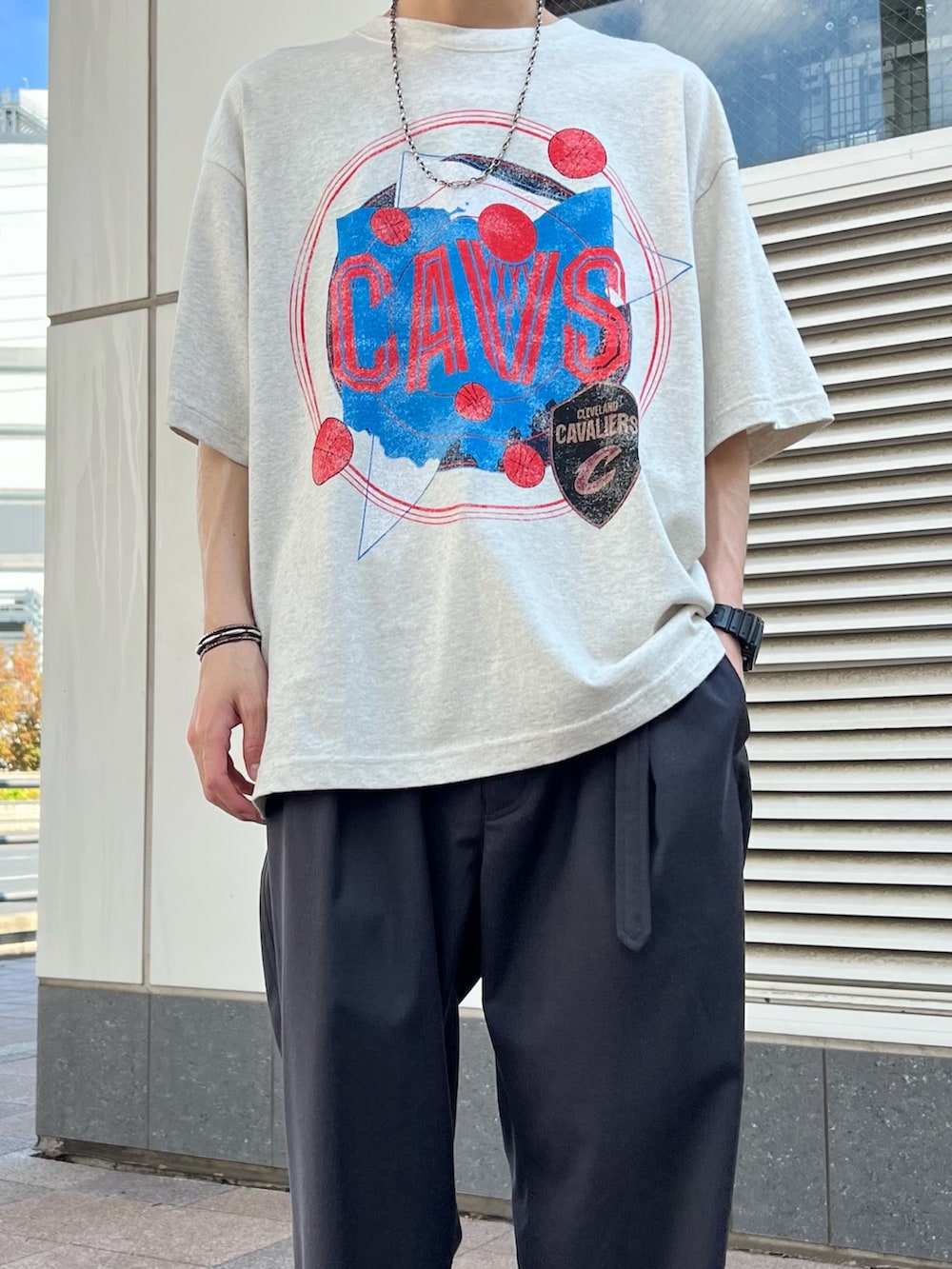 ホワイト系のTシャツ/カットソー、ブラック系のスニーカー、グレー系のスラックスを着用したメンズの春コーディネートの2枚目の写真