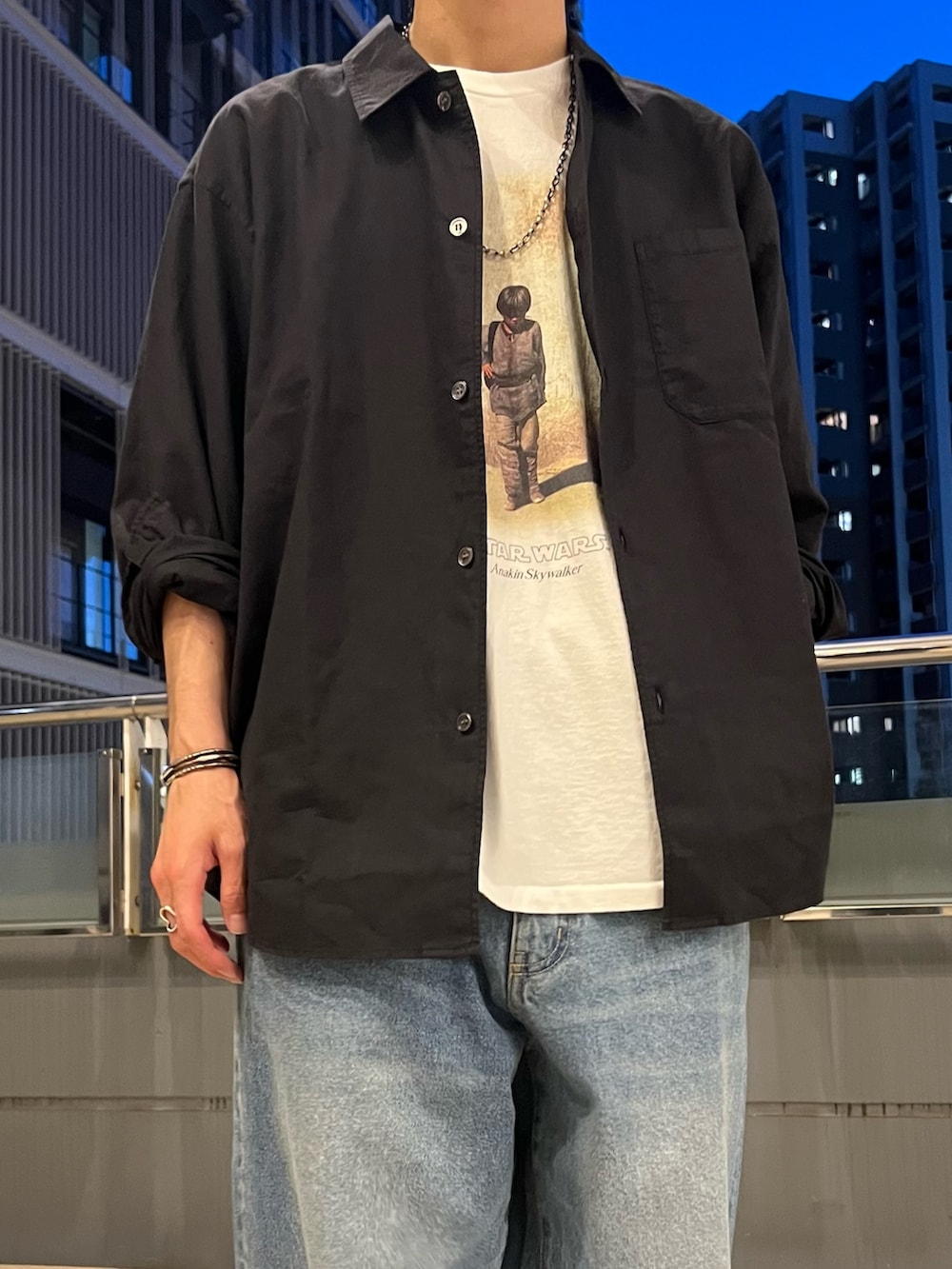 ホワイト系のTシャツ/カットソー、ブラック系のシャツ/ブラウス、ブルー系のデニムパンツを着用したメンズの春コーディネートの3枚目の写真