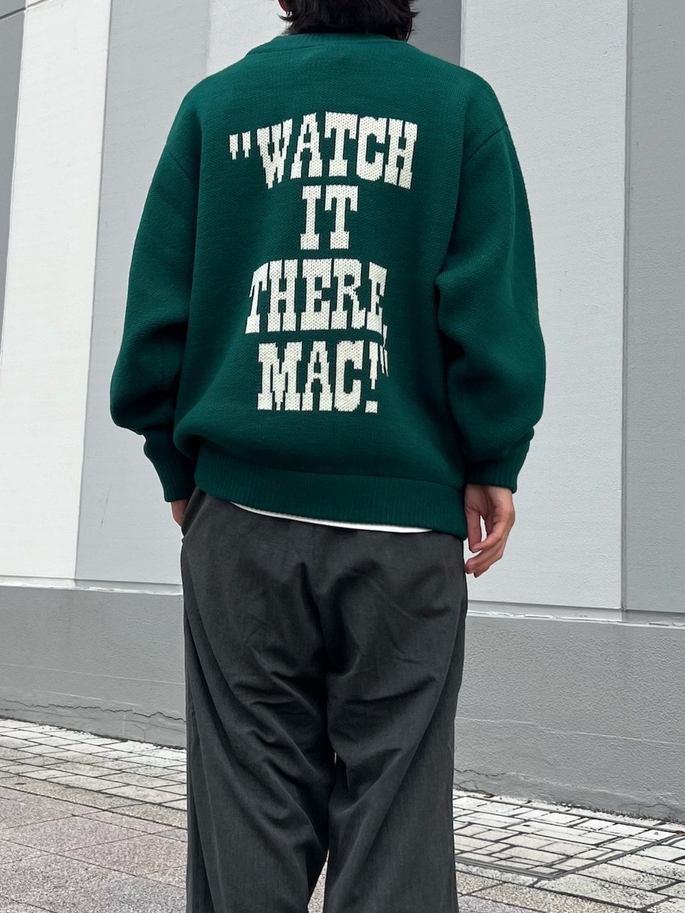 グリーン系のニット/セーター、ブラック系のサンダル、ブラック系のスラックスを着用したメンズの秋コーディネートの3枚目の写真