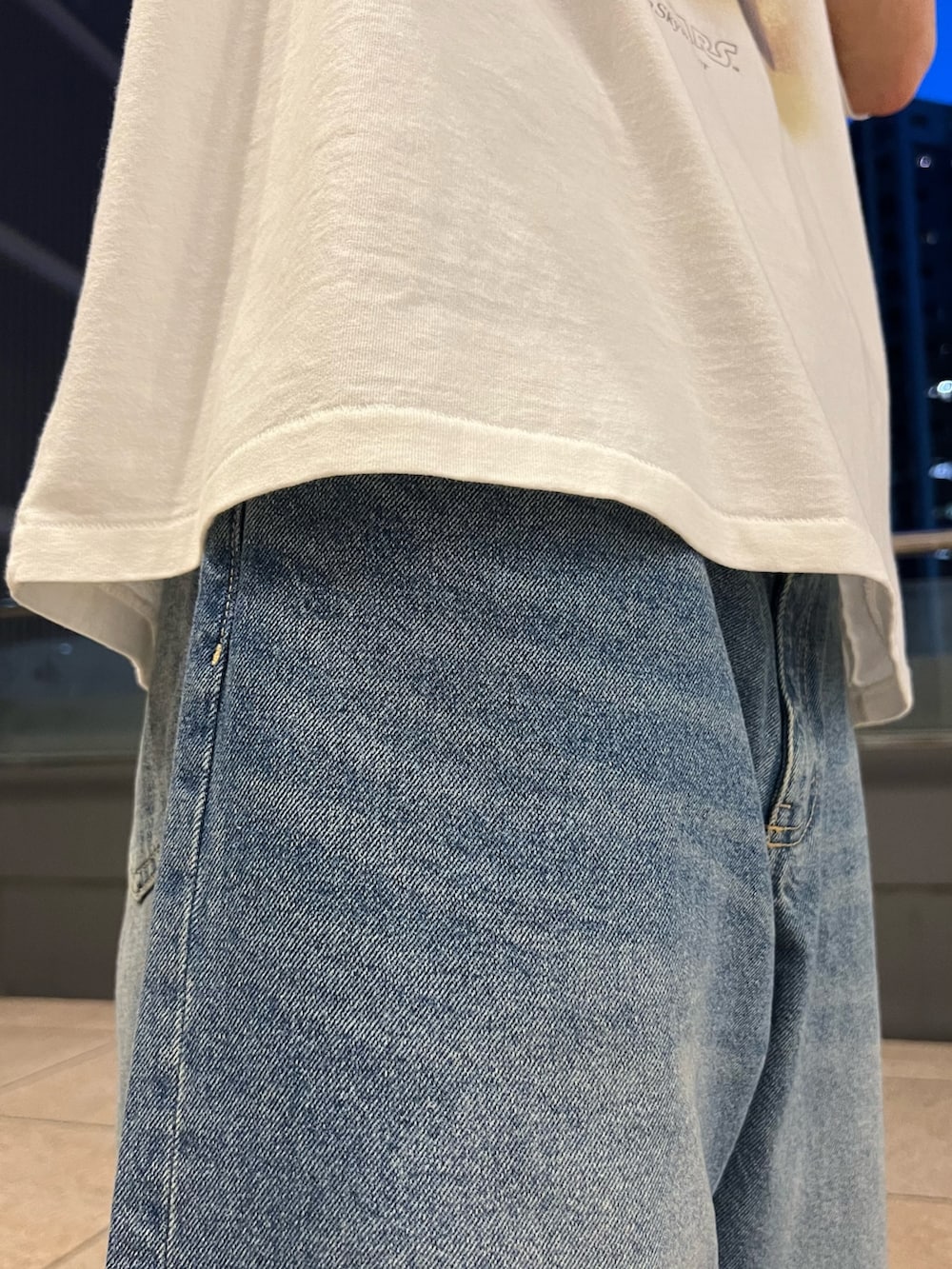 ホワイト系のTシャツ/カットソー、ブラック系のシャツ/ブラウス、ブルー系のデニムパンツを着用したメンズの春コーディネートの5枚目の写真