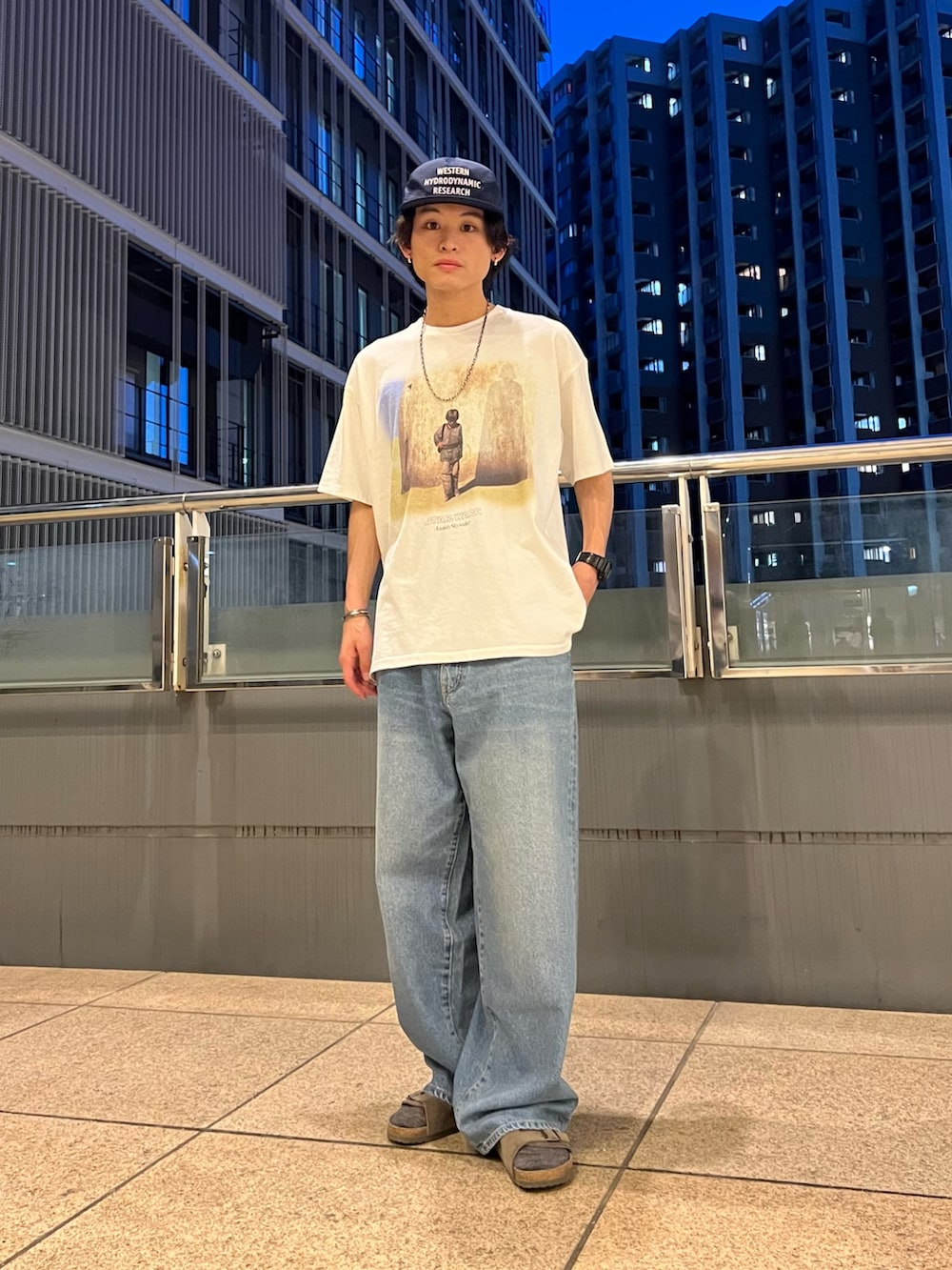 ホワイト系のTシャツ/カットソー、ブラック系のシャツ/ブラウス、ブルー系のデニムパンツを着用したメンズの春コーディネートの2枚目の写真