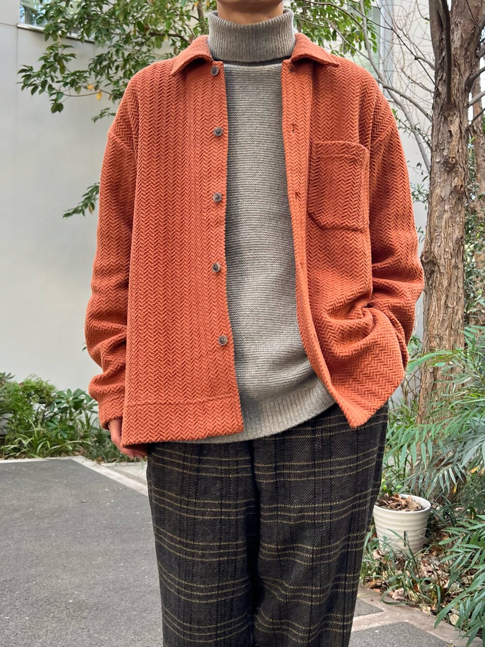 イエロー系のシャツ/ブラウス、グレー系のニット/セーター、ブラック系のスラックスを着用したメンズの冬コーディネートの2枚目の写真