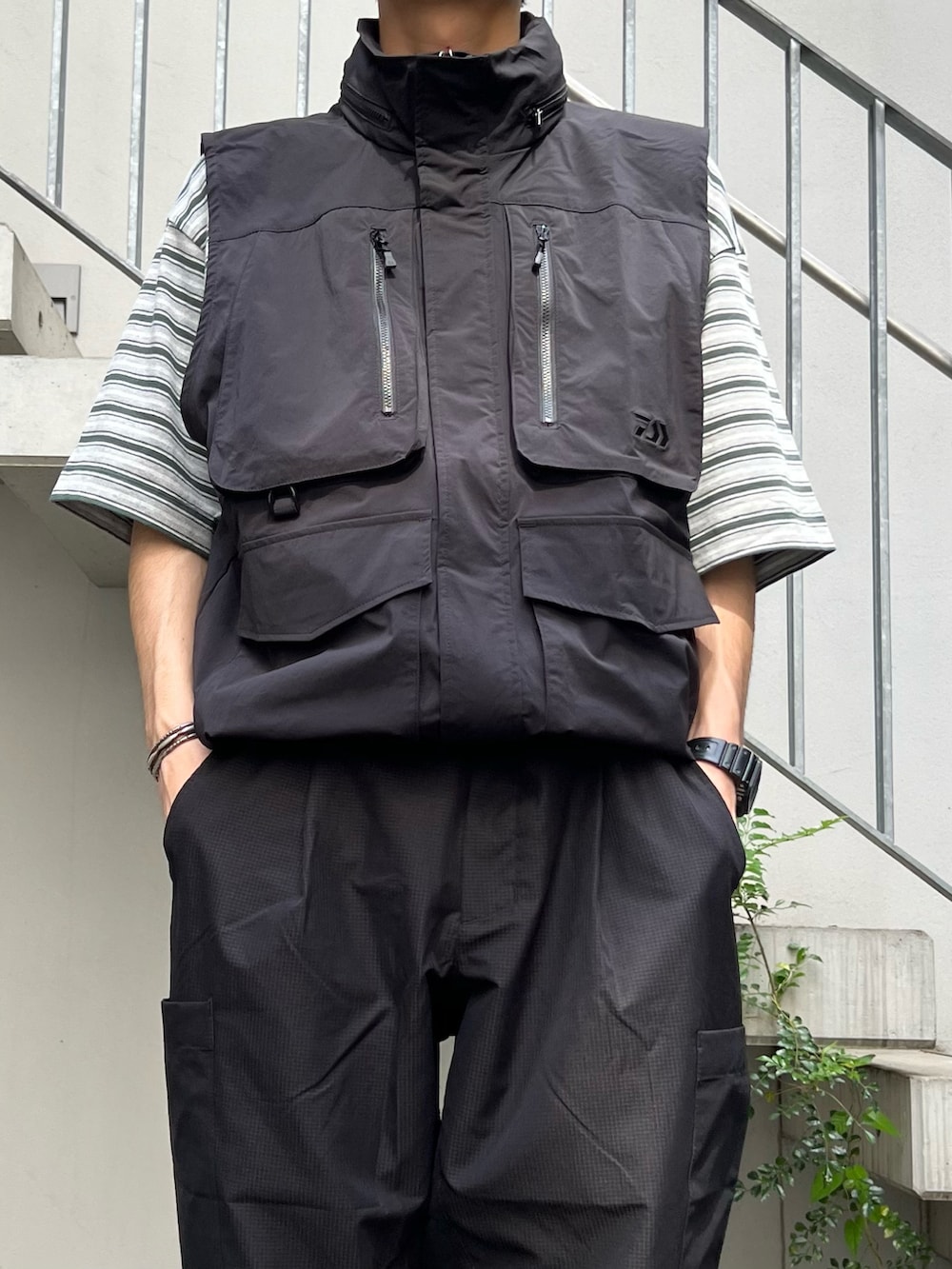 ブラック系のその他アウター、ブラック系のTシャツ/カットソー、ブラック系のスラックスを着用したメンズの春コーディネートの2枚目の写真