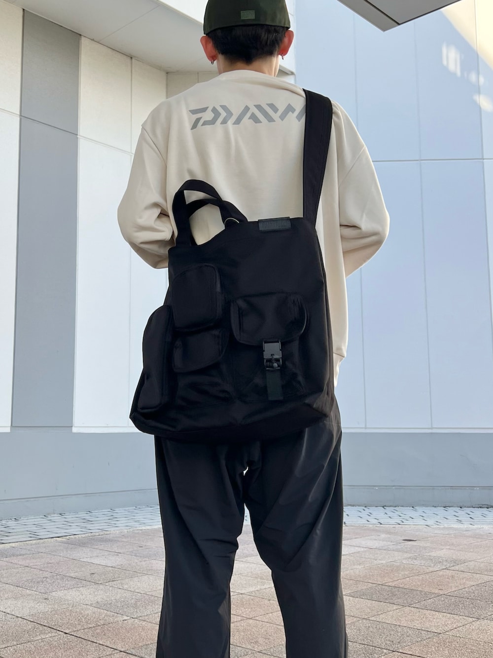 ブラック系のショルダーバッグ、ホワイト系のスウェット、ブラック系のサンダルを着用したメンズの秋コーディネートの2枚目の写真