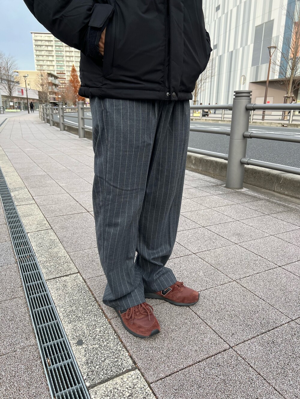 ブラック系のダウンジャケット/コート、ブラウン系のスニーカー、ブラック系のハットを着用したメンズの冬コーディネートの3枚目の写真