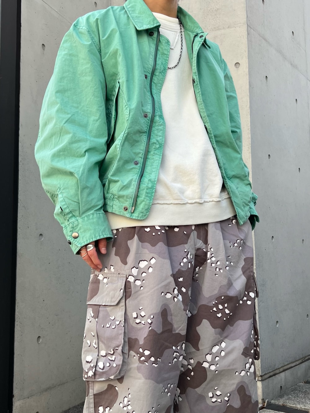 グリーン系のミリタリージャケット、グレー系のスウェット、グレー系のカーゴパンツを着用したメンズの冬コーディネートの3枚目の写真