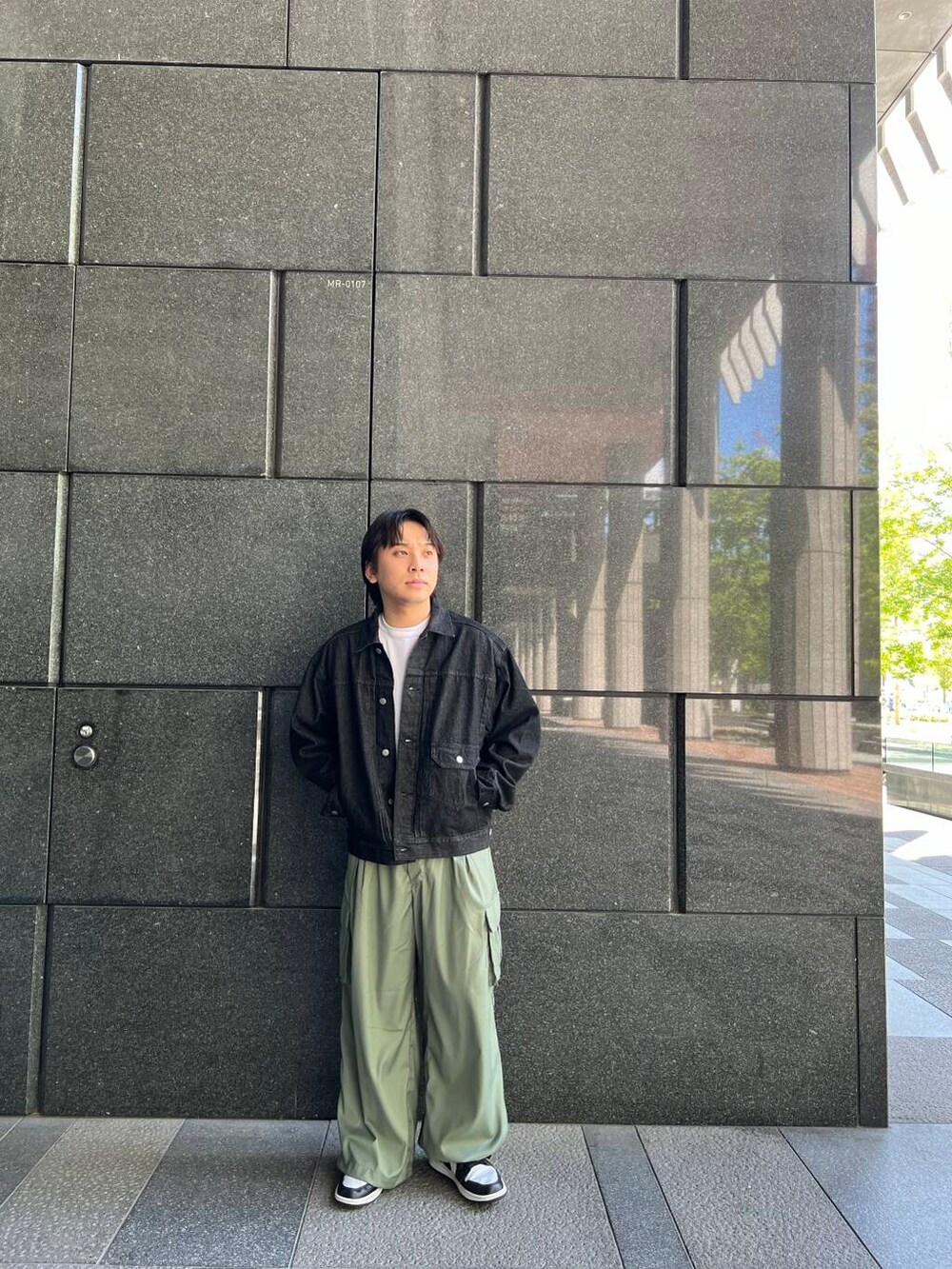 ホワイト系のTシャツ/カットソー、グリーン系のカーゴパンツ、ブラック系のデニムジャケットを着用したメンズの夏コーディネートの3枚目の写真