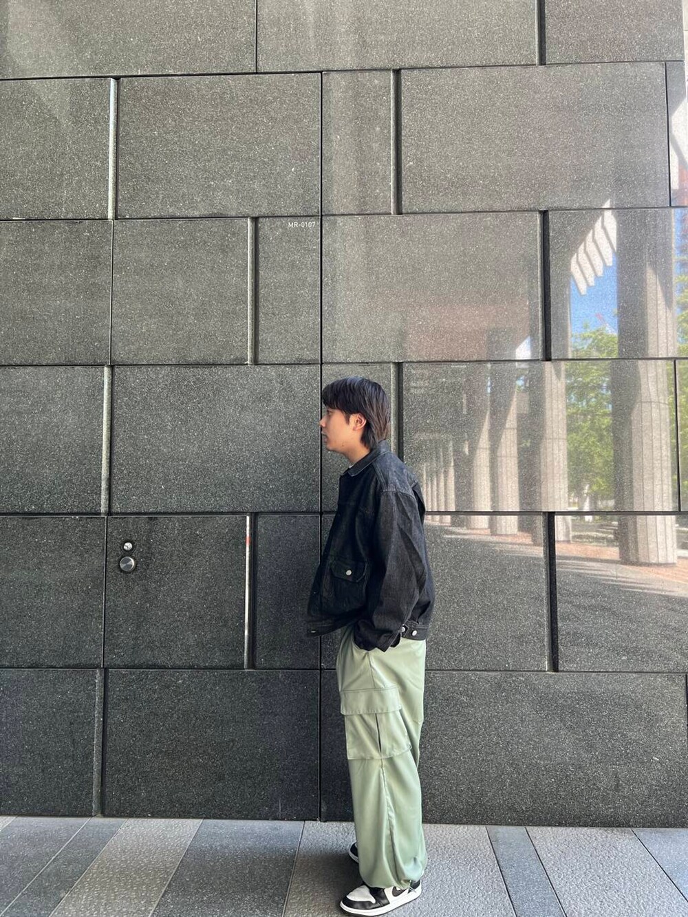 ホワイト系のTシャツ/カットソー、グリーン系のカーゴパンツ、ブラック系のデニムジャケットを着用したメンズの夏コーディネートの2枚目の写真