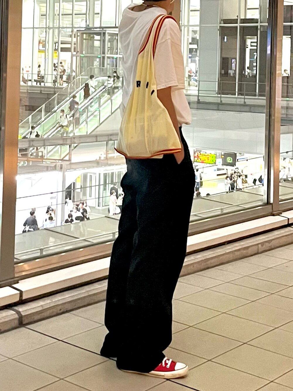 イエロー系のトートバッグ、ブラック系のスラックスを着用したメンズの夏コーディネートの2枚目の写真