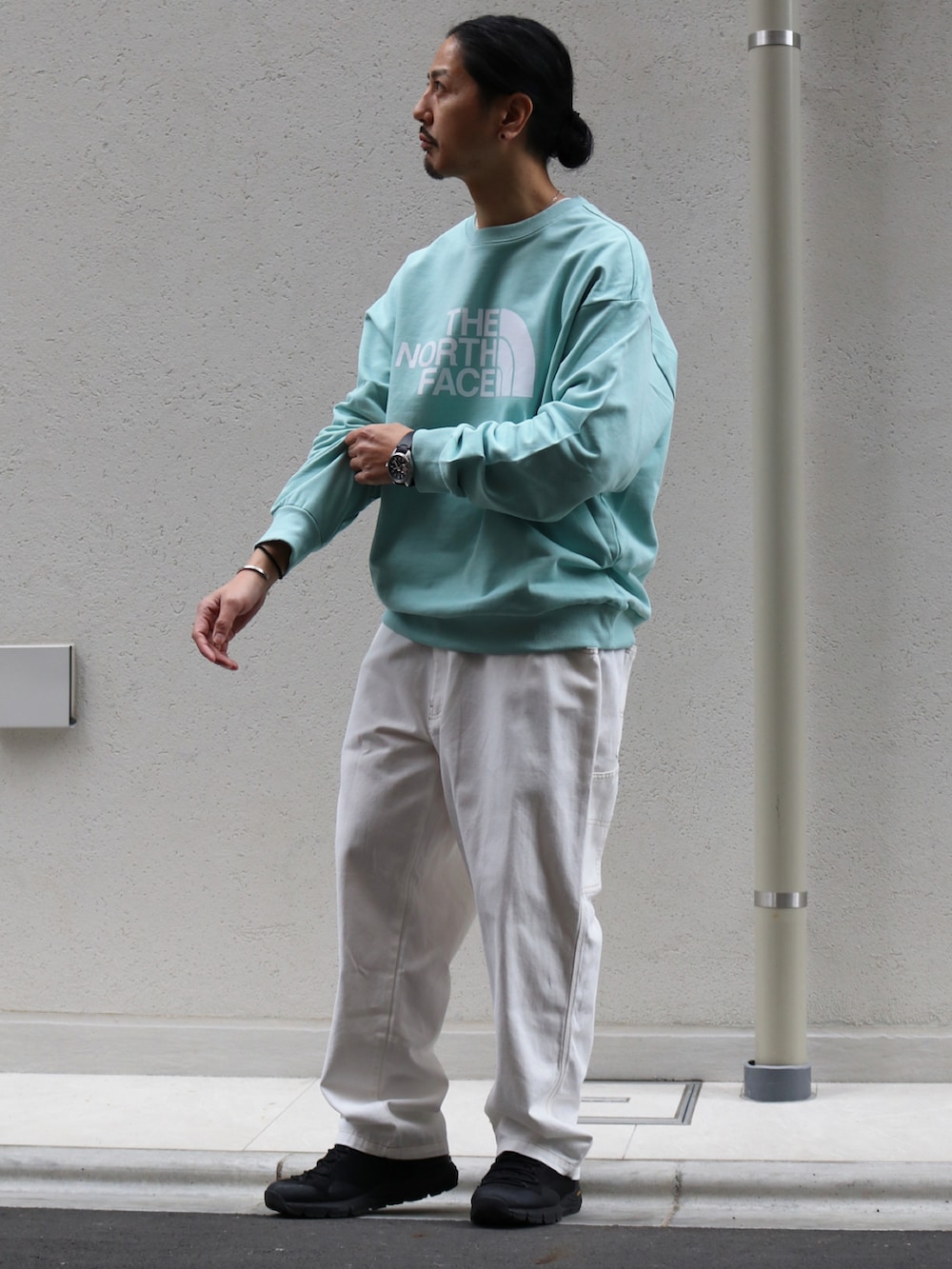 グリーン系のスウェット、ホワイト系のデニムパンツ、グレー系のリングを着用したメンズの冬コーディネートの2枚目の写真