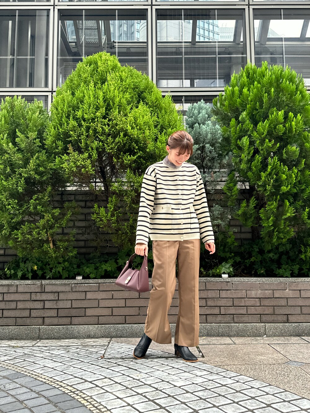 ベージュ系のカーディガン/ボレロ、グレー系のTシャツ/カットソー、ブラック系のブーツを着用したレディースの秋コーディネートの2枚目の写真