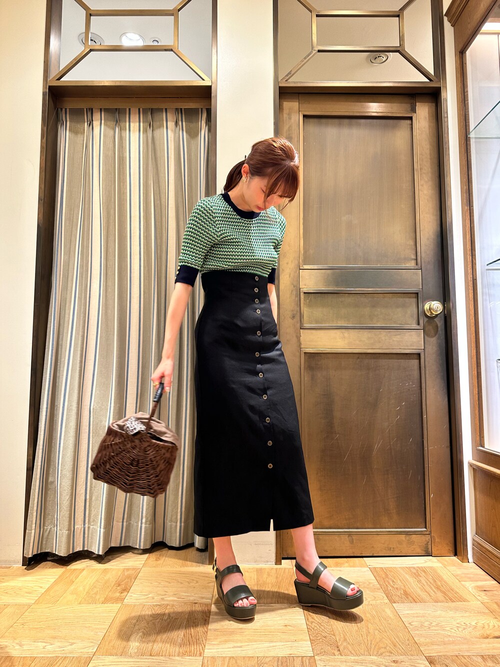 ブラック系のスカートを着用したレディースの夏コーディネートの2枚目の写真