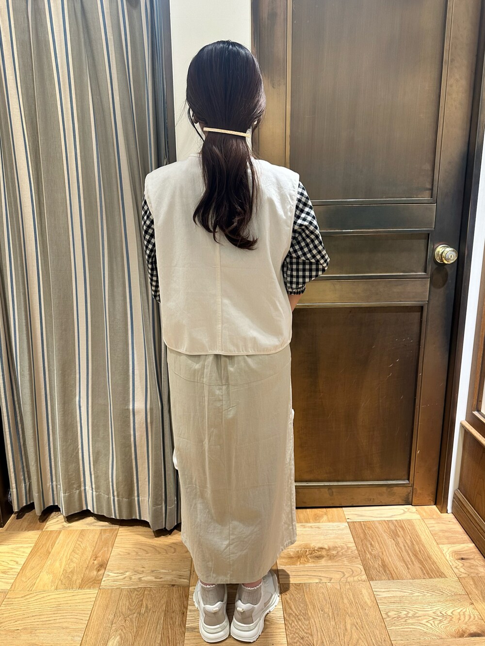 ホワイト系のシャツ/ブラウス、ホワイト系のベスト、ブラック系のハンドバッグを着用したレディースの春コーディネートの3枚目の写真