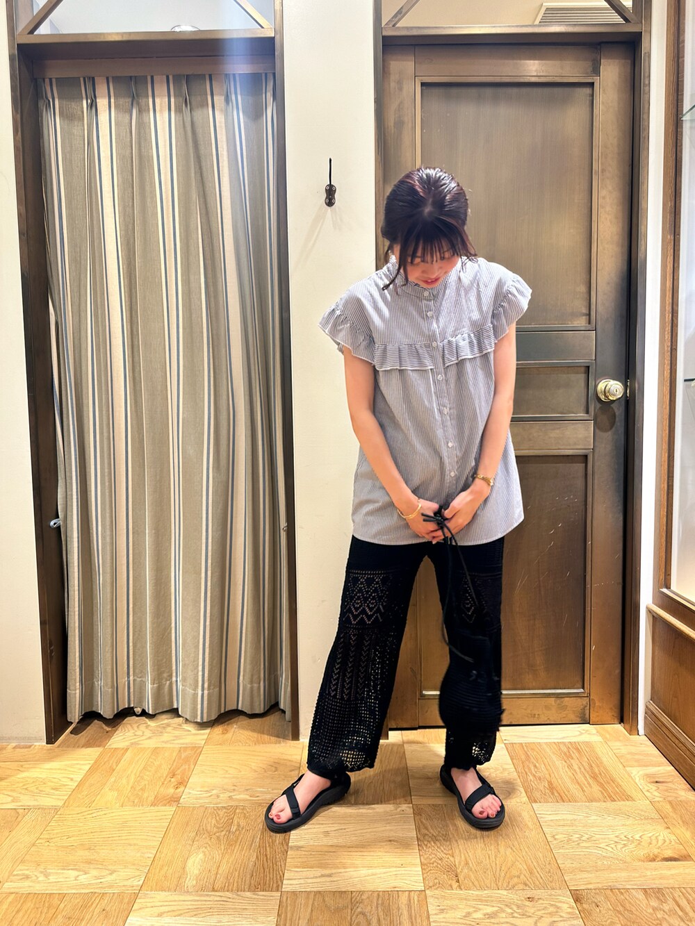 ブルー系のシャツ/ブラウス、ブラック系のその他パンツ、ブラック系のハンドバッグを着用したレディースの夏コーディネートの2枚目の写真