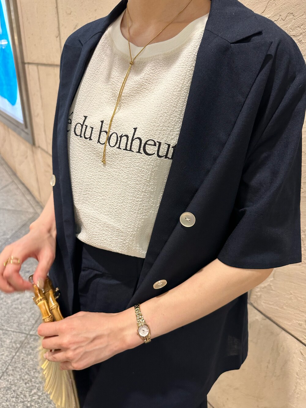 ブルー系のノーカラージャケット、ブルー系のその他パンツ、ゴールド系のドレスシューズを着用したレディースの夏コーディネートの2枚目の写真