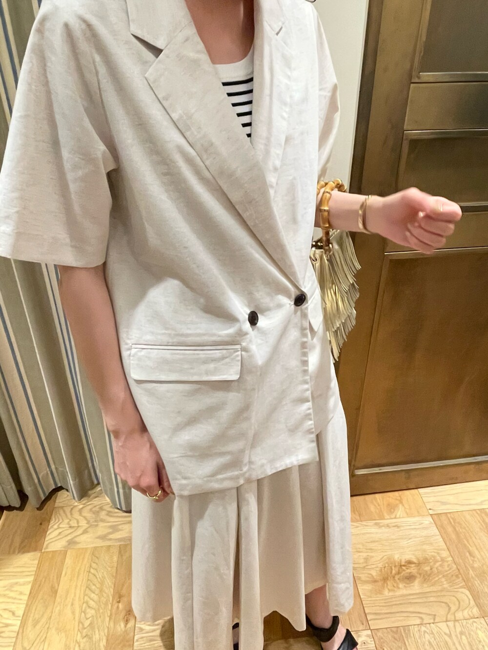 ホワイト系のタンクトップ、ホワイト系のノーカラージャケット、ホワイト系のスカートを着用したレディースの春コーディネートの3枚目の写真