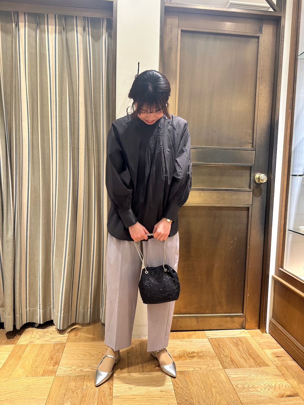 ブラック系のシャツ/ブラウス、ブラック系のハンドバッグ、グレー系のその他パンツを着用したレディースの春コーディネートの2枚目の写真