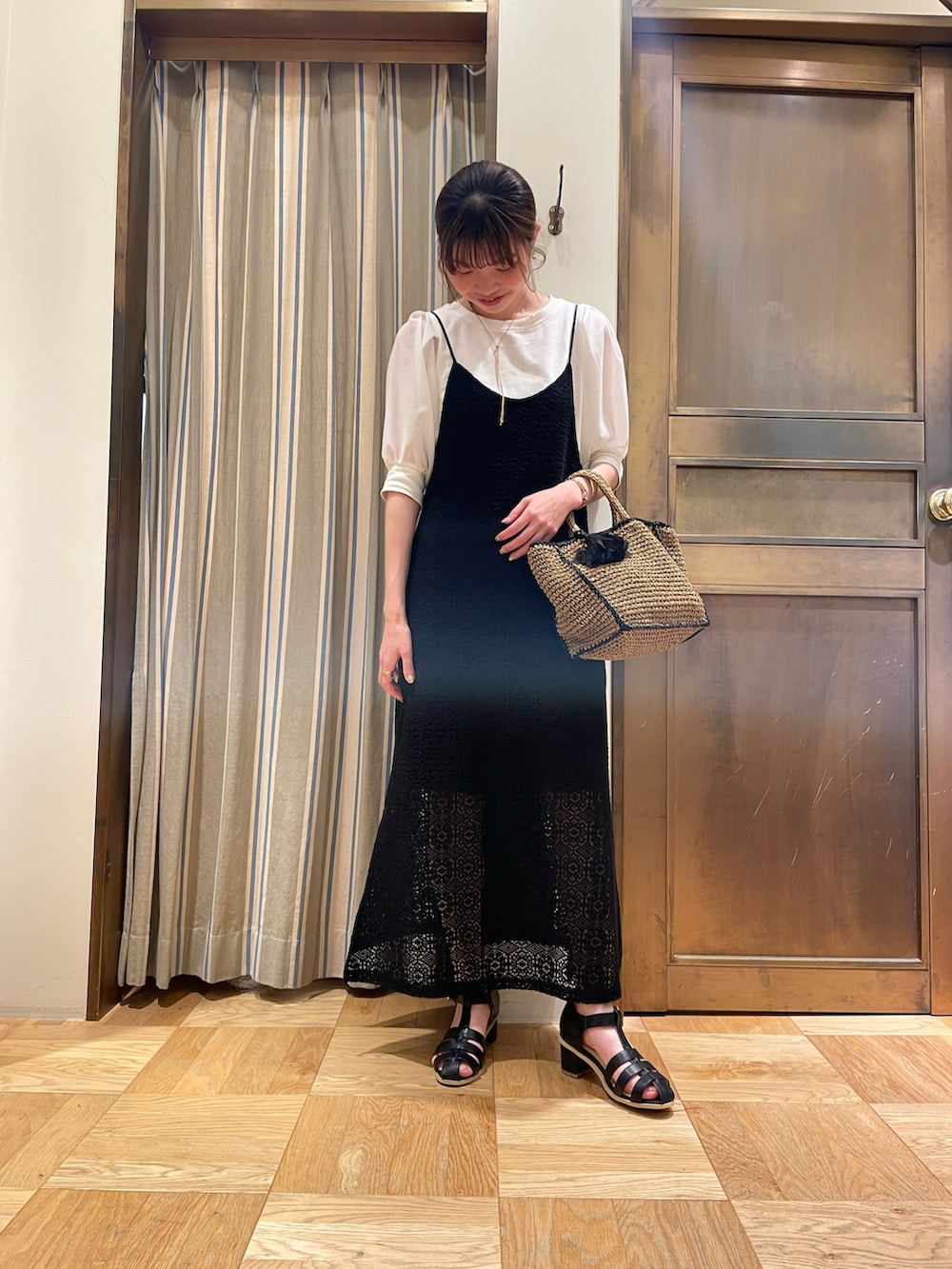 ホワイト系のTシャツ/カットソー、ブラック系のワンピース、ブラック系のサンダルを着用したレディースの春コーディネートの2枚目の写真