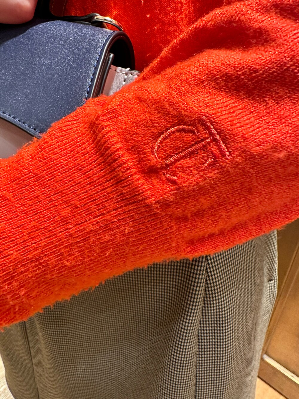 レッド系のニット/セーター、ブラウン系のスカートを着用したレディースの冬コーディネートの3枚目の写真