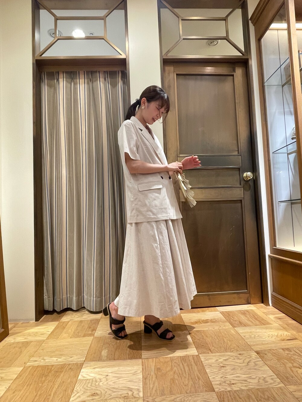 ホワイト系のタンクトップ、ホワイト系のノーカラージャケット、ホワイト系のスカートを着用したレディースの春コーディネートの2枚目の写真