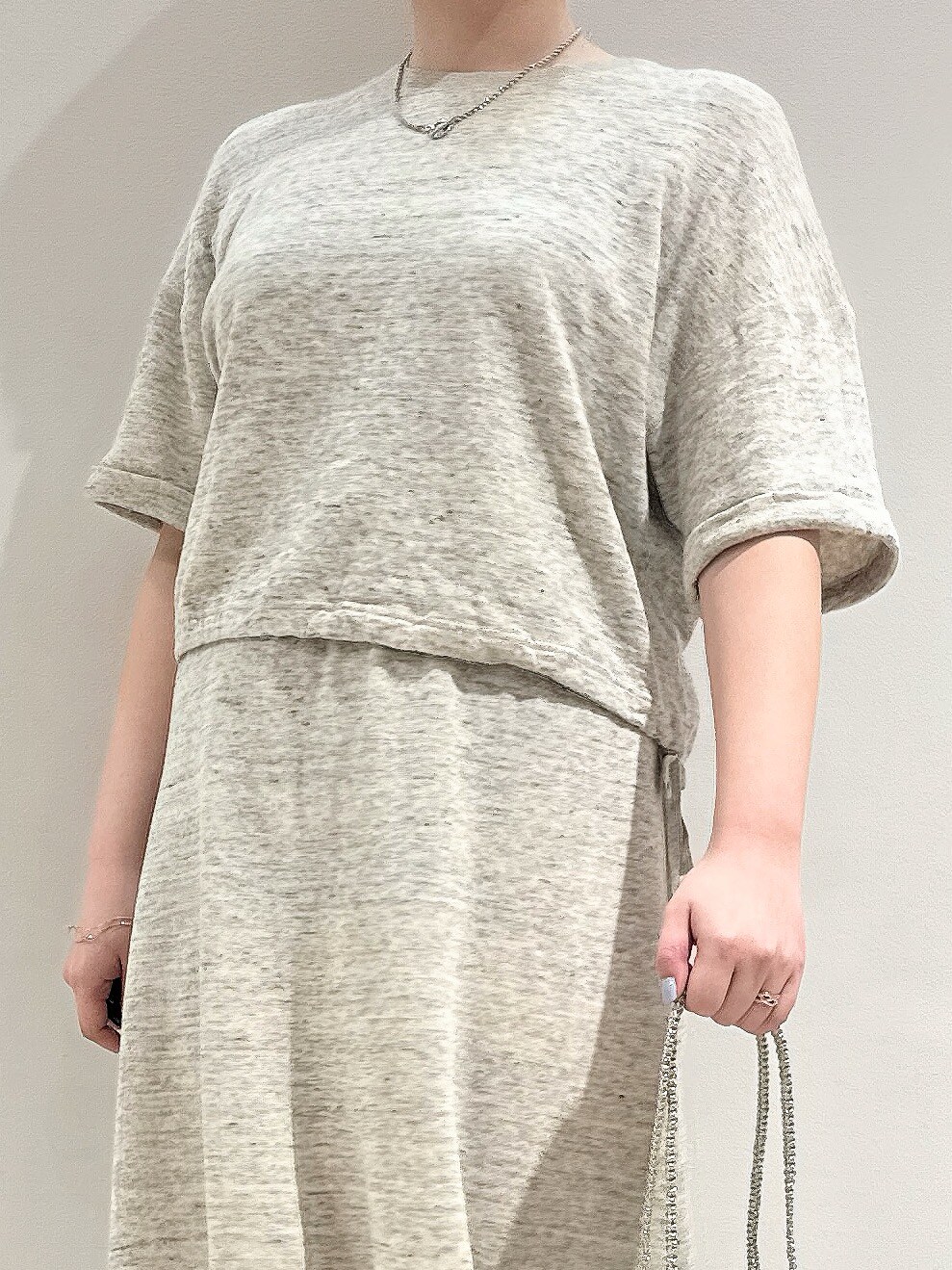 グレー系のTシャツ/カットソー、グレー系のスカート、シルバー系のトートバッグを着用したレディースの春コーディネートの3枚目の写真